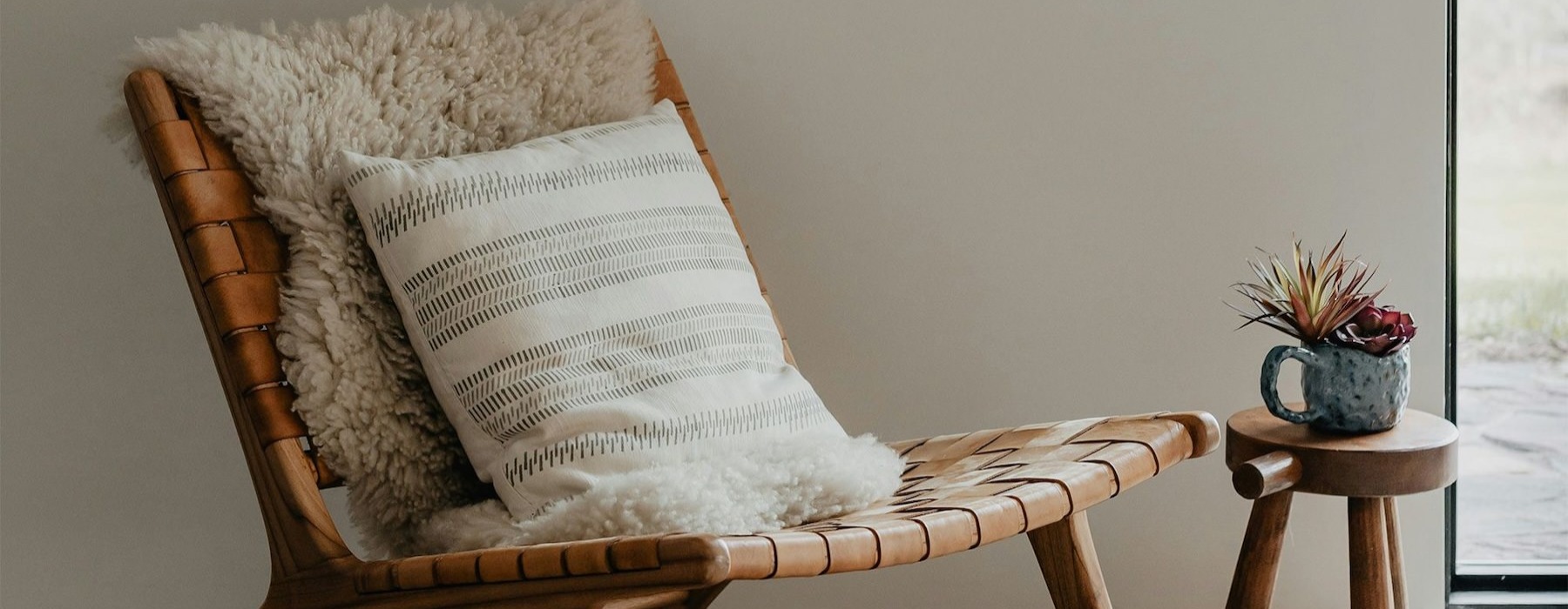 a chair in a room with a cup on a small table