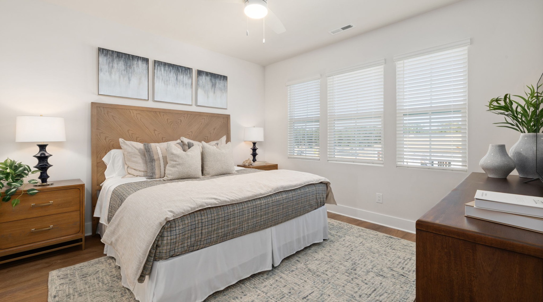 Bedroom at Oaks at Wendell with large windows, a ceiling fan, and space for a bed, nightstands, and dresser.