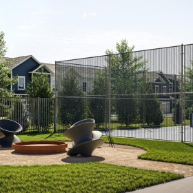 an outside lounge with chairs in front of a pickleball court