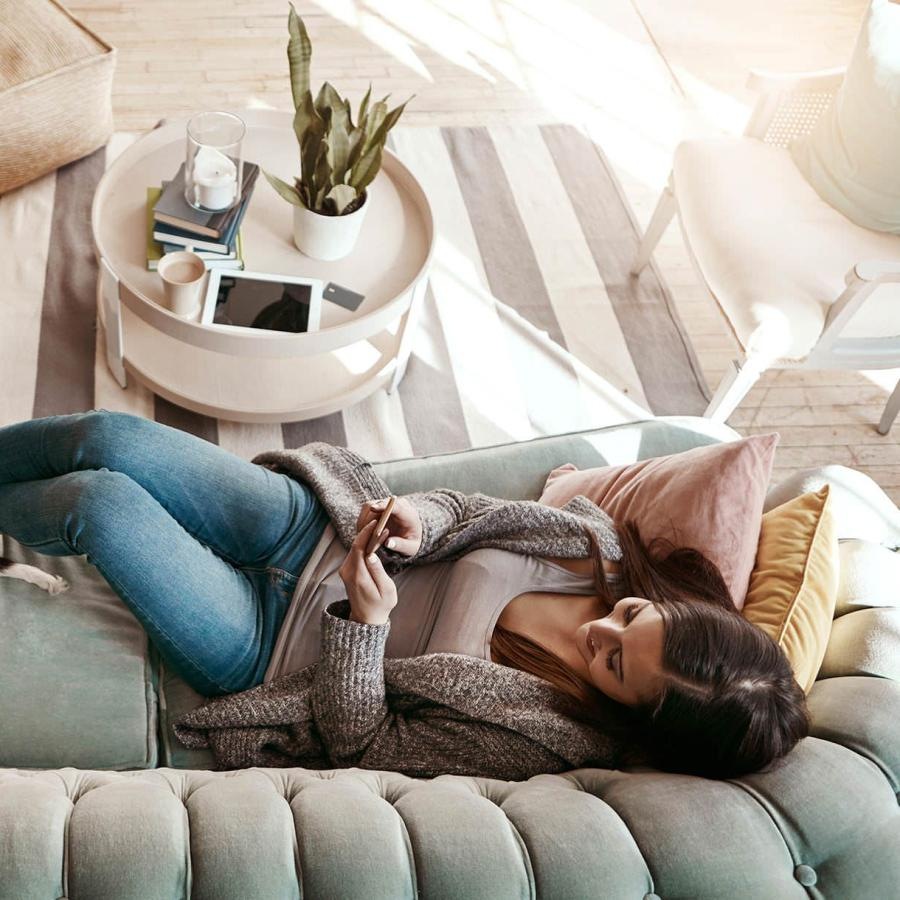 a person lying on a couch with a dog