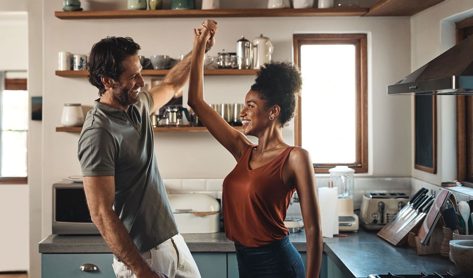 a couple eating food in a kitchen
