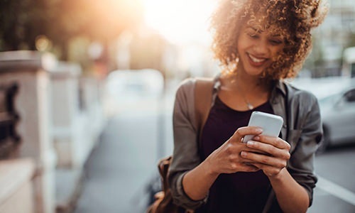 a woman smiling and looking at her device